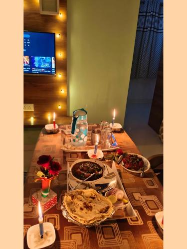 a table with candles and plates of food on it at The Grand Crest Residency in Panchgani
