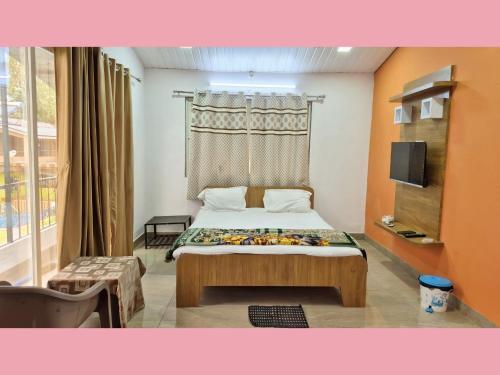 a small bedroom with a bed and a window at The Grand Crest Residency in Panchgani