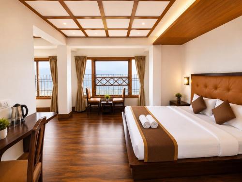 a hotel room with a bed and a table and chairs at Gangtok Central Rooms in Gangtok