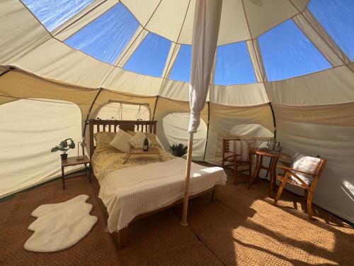 a bedroom with a bed in a tent at Sunset Tent in Sageau