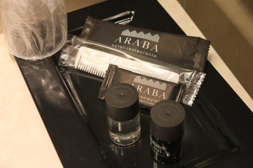a black table with a bottle of alcohol and a blow dryer at Hotel Araba in Vitoria-Gasteiz