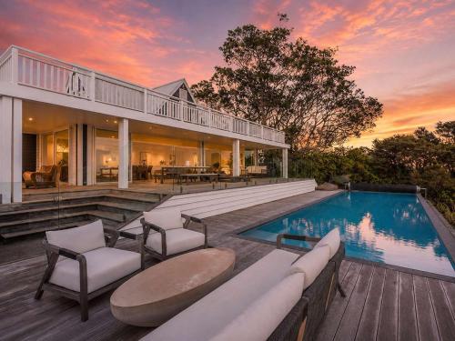 a large house with a swimming pool and a deck at No 63 - Stay Waiheke in Onetangi
