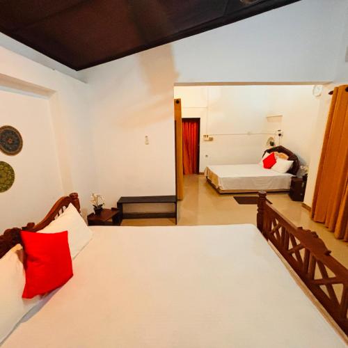 a bedroom with two beds and a mirror at Orchid Resort in Medawachchiya