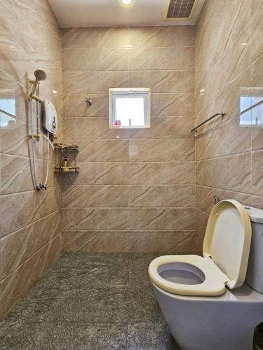 a bathroom with a toilet and a window at Large Group KTV Stay, Near Setia Alam, Klang in Klang
