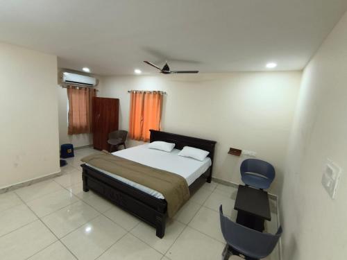 a bedroom with a bed and a desk and a chair at Hotel N Pride in Guntūr