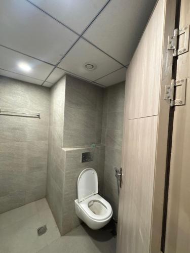 a bathroom with a toilet in a room at the Aurelia estate studio apartment Alpha 2 in Greater Noida