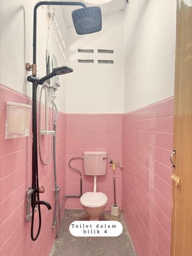 a pink bathroom with a toilet and a shower at Harumi Guesthouse in Marang