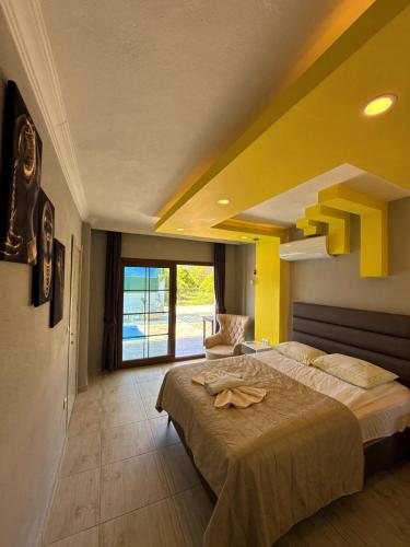 a bedroom with a large bed and a yellow ceiling at VİLLA Terasa in Fethiye
