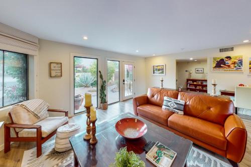 a living room with a leather couch and a table at Adobe Barona Dream in Palm Springs