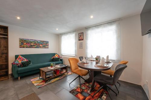 a living room with a green couch and a table at Familien Apartment bei Legoland 8 Min, Spielplatz & Netflix in Ichenhausen