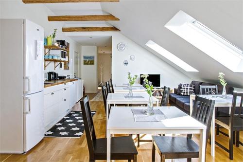 a kitchen and dining room with white tables and chairs at Villa Sandby B&B in Borrby