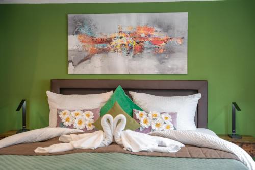 a bedroom with a bed with a painting on the wall at Familien Apartment bei Legoland 8 Min, Spielplatz & Netflix in Ichenhausen