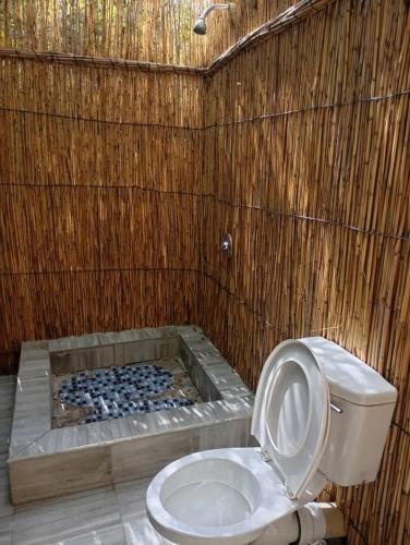 a bathroom with a toilet in a wooden wall at Kashete Plains Expedition & Campsite - Okavango Eastern Panhandle in Goa