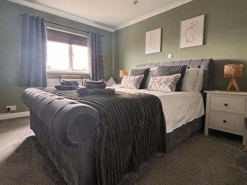 a bedroom with a large bed with blue walls at Craster Crew Quarters in Craster