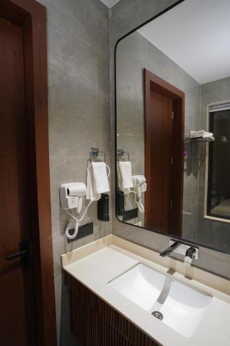 a bathroom with a sink and a large mirror at Hotel Shivora in Bathinda