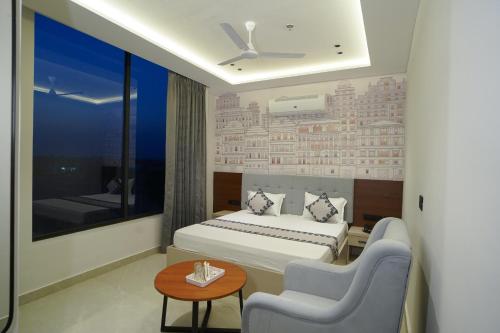a hotel room with a bed and two chairs at Hotel Shivora in Bathinda
