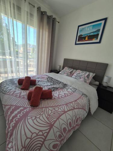 a bedroom with a bed with red pillows on it at Charmant T2 in Calvi
