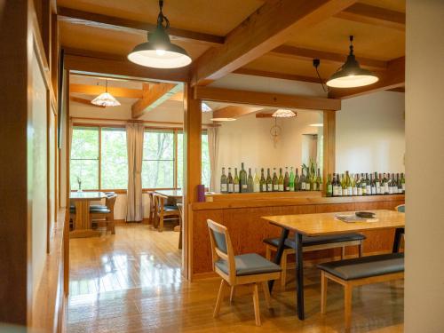 a restaurant with a table and chairs and wine bottles at Ikiru Lodge in Yamanouchi
