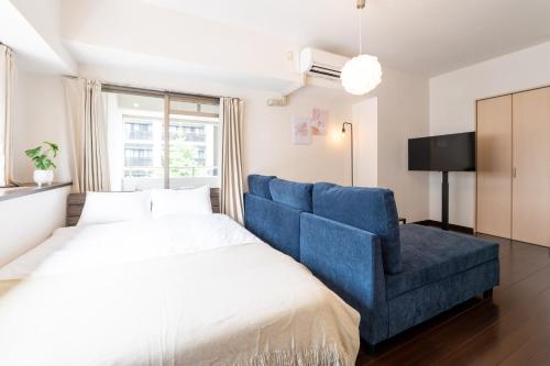 a bedroom with a bed and a blue chair at Ruis Hakata in Fukuoka