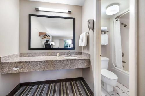 a bathroom with a sink and a mirror at Super 8 by Wyndham Riviera Beach West Palm Beach in Riviera Beach