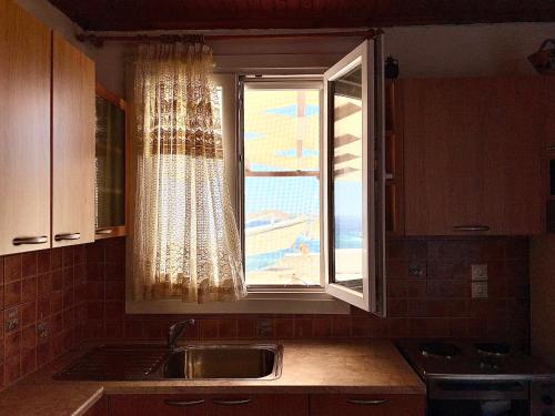 a kitchen with a sink and a window at Lotos Suite in Kini