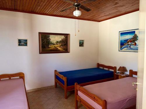 a bedroom with two beds and a ceiling fan at Lotos Suite in Kini