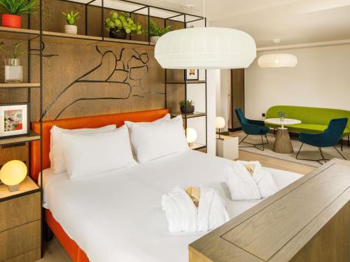 a bedroom with a large white bed with two towels at ibis Styles Edinburgh St Andrew Square in Edinburgh