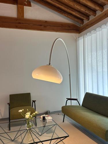 a living room with a green couch and a lamp at Stay Jian in Daegu