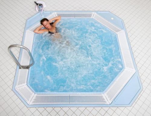 a man is in a swimming pool in a chlorine at Donna Hotel Klosterhof in Neukirchen beim Heiligen Blut