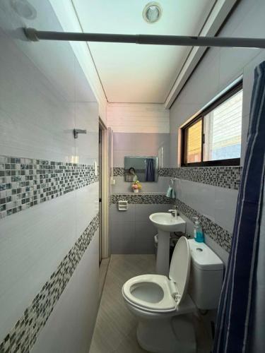 a bathroom with a toilet and a sink at Peach Haven in Cebu City
