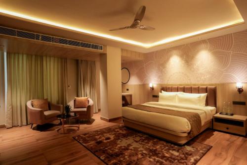 a hotel room with a bed and a chair at Barsana Hotel & Resorts in Jaipur