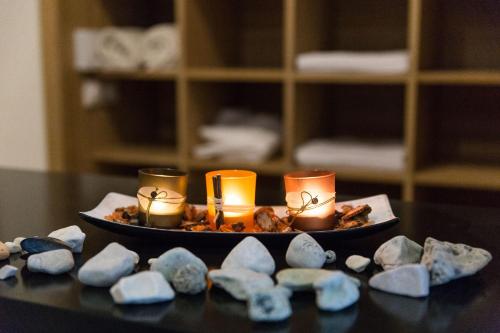a plate with candles and rocks on a table at Hotel Crikvenica in Crikvenica