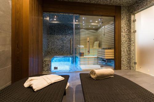 una camera con porta a vetri e asciugamani su una panca di Hotel Crikvenica a Crikvenica