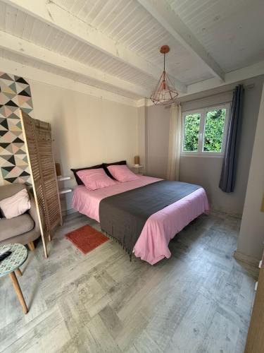 ein Schlafzimmer mit einem großen Bett mit rosa Bettwäsche in der Unterkunft Gites Matilon, 5 min Eugénie les bains in Buanes