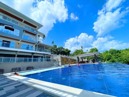 a large swimming pool next to a building at Highlights Taal Lake View Resort in Santol
