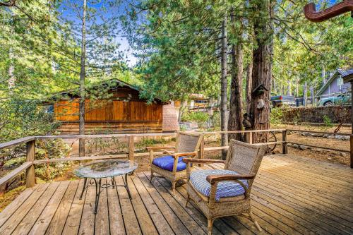 two chairs and a table on a wooden deck at Walden in the Woods in Idyllwild