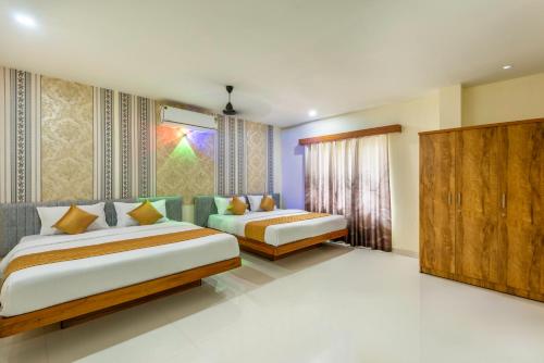 a bedroom with two beds and a window at Hotel Beverly Residency - Near Nileshwar Railway Station in Nīleshwar