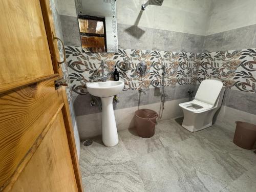 a bathroom with a sink and a toilet at ROYALE PEAKS villa sonamarg Rd in Harganyiwan