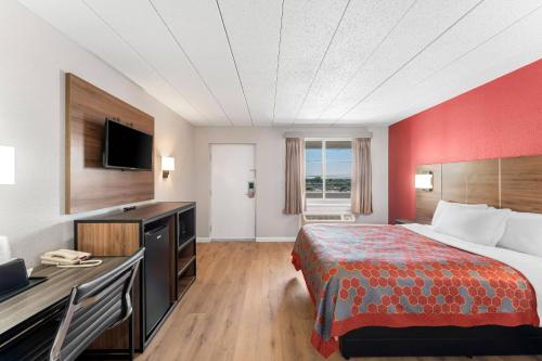 a hotel room with a bed and a desk at Econo Lodge Cranston - Providence in Cranston