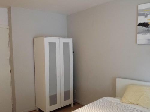 a bedroom with a white cabinet next to a bed at Central Yellow Apartment in Brussels