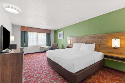 a hotel room with a bed and a flat screen tv at Quality Inn Evanston near Wyoming Downs in Evanston