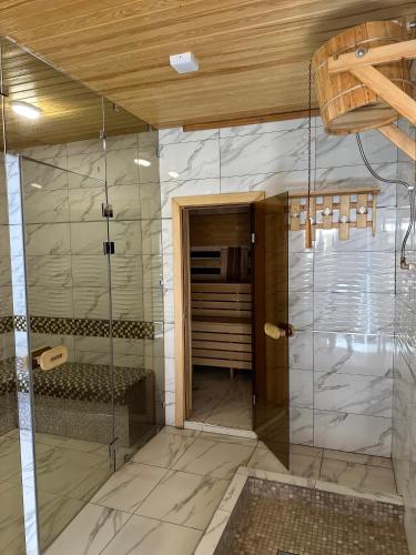 a bathroom with a shower with a glass door at Hotel Dera Bukhara in Bukhara