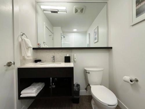 ein Badezimmer mit Toilette, Waschbecken und Spiegel in der Unterkunft Quality Inn in Nanaimo