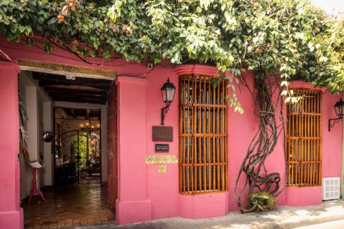 a pink building with a tree in front of it at Hotel Bantu by Faranda Boutique, a member of Radisson Individuals in Cartagena de Indias