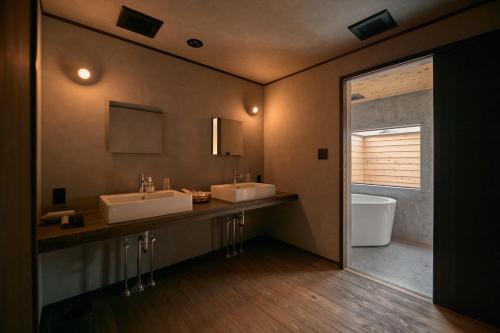 a large bathroom with two sinks and a tub at 安宅ノ宿 沖 in Komatsu