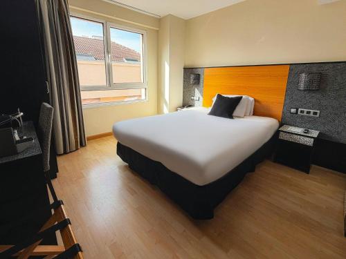 a hotel room with a large bed with a window at Hotel Faranda Pathos Gijón, Ascend Hotel Collection in Gijón