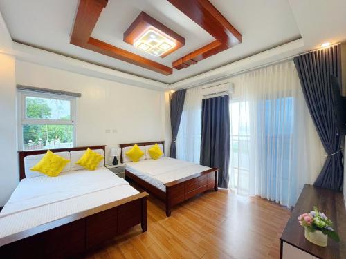 a bedroom with two beds with yellow pillows at Highlights Taal Lake View Resort in Santol