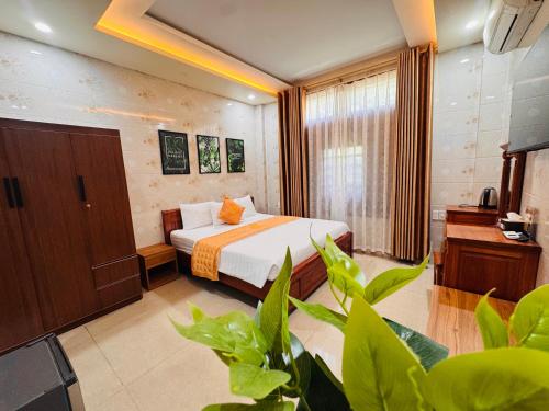a hotel room with a bed and some plants at Thịnh Vượng Hotel in Dong Hoi
