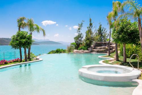 a swimming pool with the ocean in the background at Le Meridien Bodrum Beach Resort in Bogazici