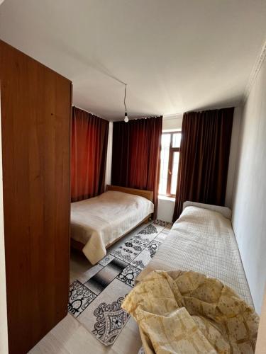 a small bedroom with two beds and a window at Diamond Resort Cottage Issyk-Kul in Bosteri